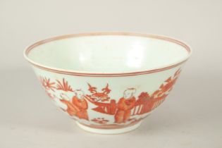 A CHINESE COPPER RED AND WHITE PORCELAIN BOWL, painted with scenes of boys. 20.5cms diameter.