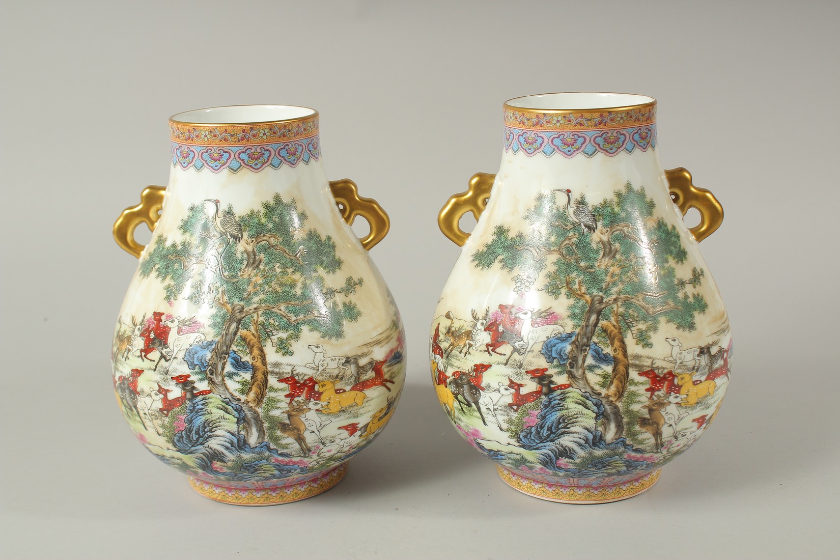 A PAIR OF CHINESE PORCELAIN TWO HANDLED VASES, deer in a landscape. 23cms high. - Image 2 of 2