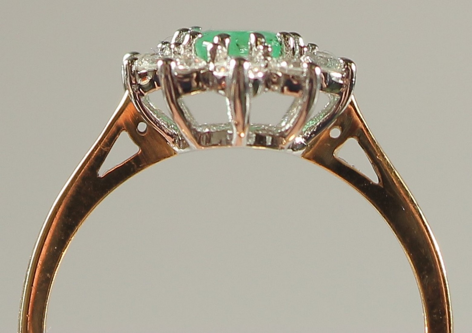 AN 18CT YELLOW AND WHITE GOLD OVAL EMERALD AND RBC DIAMOND CLUSTER RING. Emerald 0.80ct. Diamonds - Image 2 of 6