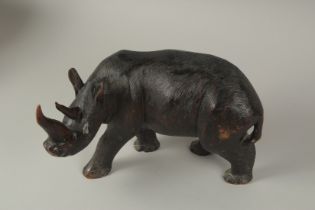 A HEAVY CARVED WOOD RHINO, probably Black Forest. 12ins long x 7.5ins high.