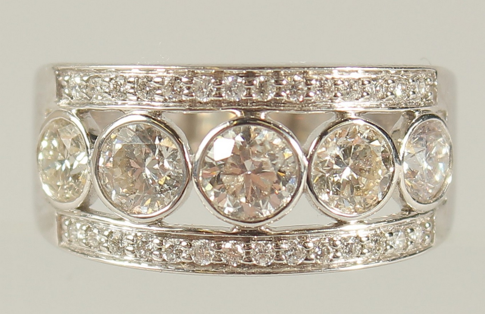 AN 18CT WHITE GOLD FIVE STONE DIAMOND RING with diamond band.