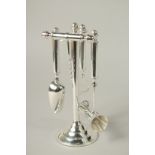 A SET OF FOUR SILVER PLATED BAR TOOLS on a stand.