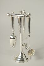 A SET OF FOUR SILVER PLATED BAR TOOLS on a stand.