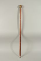 A WALKING STICK with four faced brass Buddha handle.