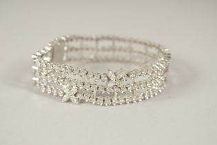 A SUPERB RUSSIAN .750 WHITE GOLD THREE ROW BRACELET, set with two flowers. 18cms long. 40grams.