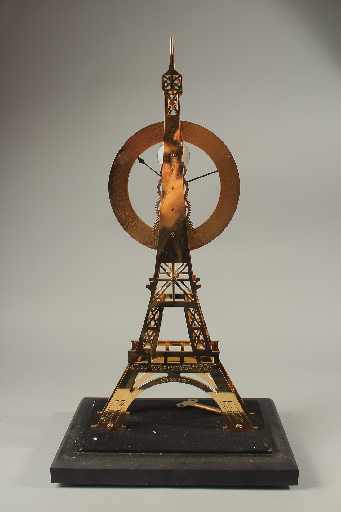 AN EIFFEL TOWER BRASS SKELETON CLOCK in a glass case. 56cms high. - Image 4 of 4