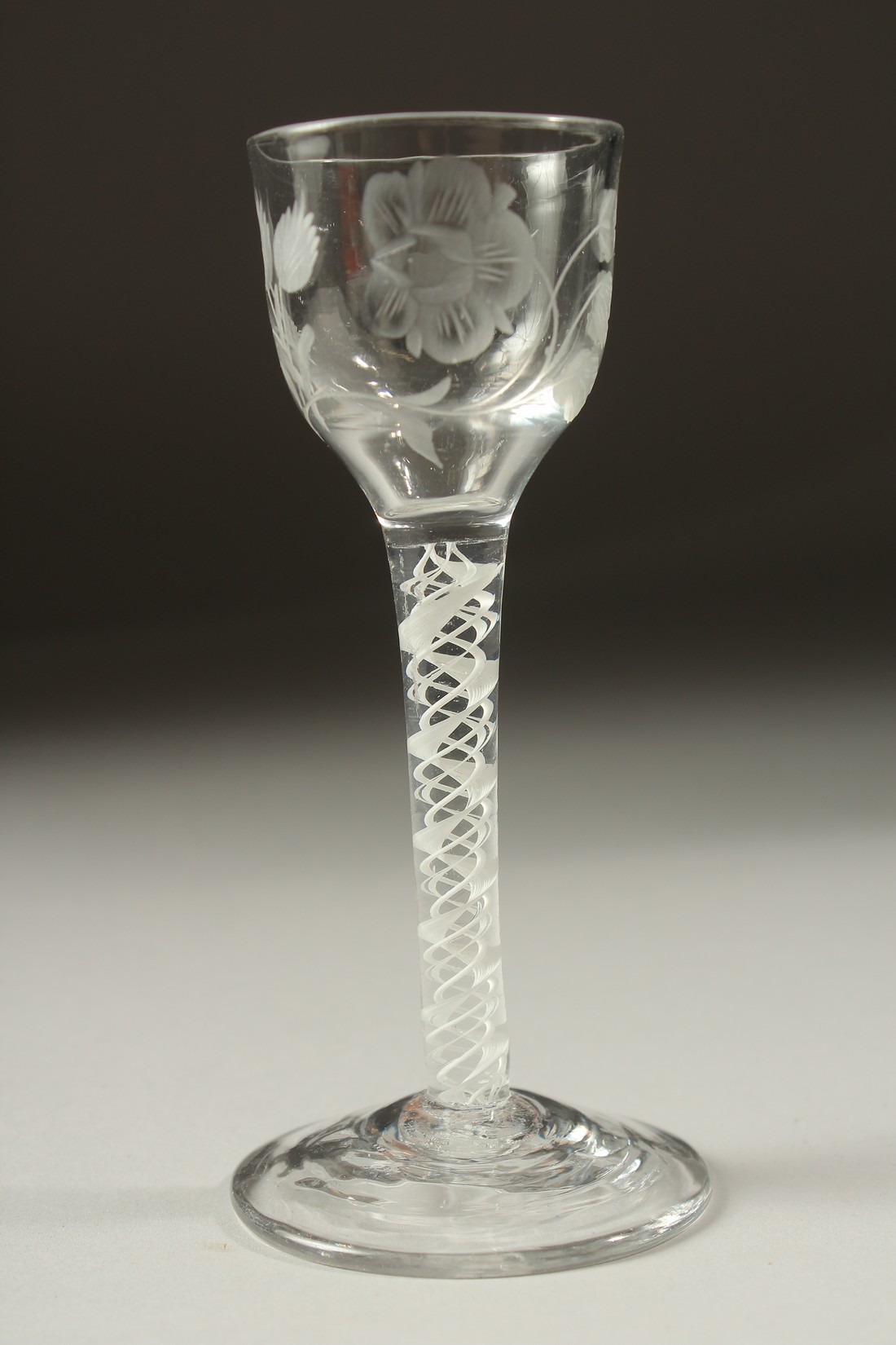 A GEORGIAN WINE GLASS, the bowl engraved with roses and opaque twist stem. 5.75ins high.