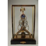 A MOONPHASE BRASS SKELETON CLOCK with eagle, in a glass case. 42cms high.