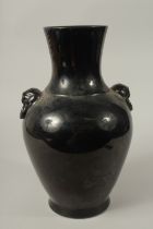A CHINESE PORCELAIN BLACK VASE with lion ring handles. 36cms high.