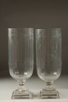 A PAIR OF CUT GLASS HURRICANE LAMPS on square stepped bases.