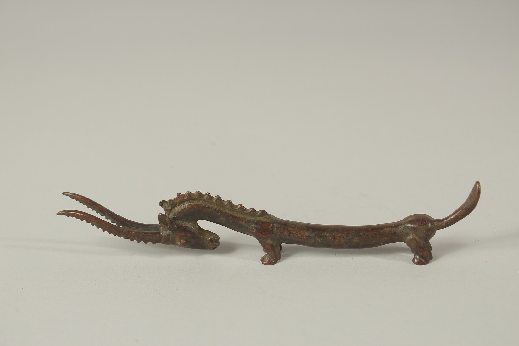 A LONG JAPANESE BRONZE GOAT BRUSH REST. 18cms long.