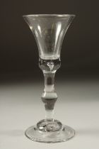 A GEORGIAN WINE GLASS with plain inverted bell bowl and knop stem. 7ins high.