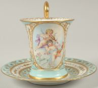 A GOOD DRESDEN CUP AND SAUCER with blue ground, painted with an oval of a two cupids playing