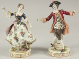 A GOOD PAIR OF PORCELAIN FIGURES OF A GALLANT AND LADY DANCING, on circular bases. 9ins high.