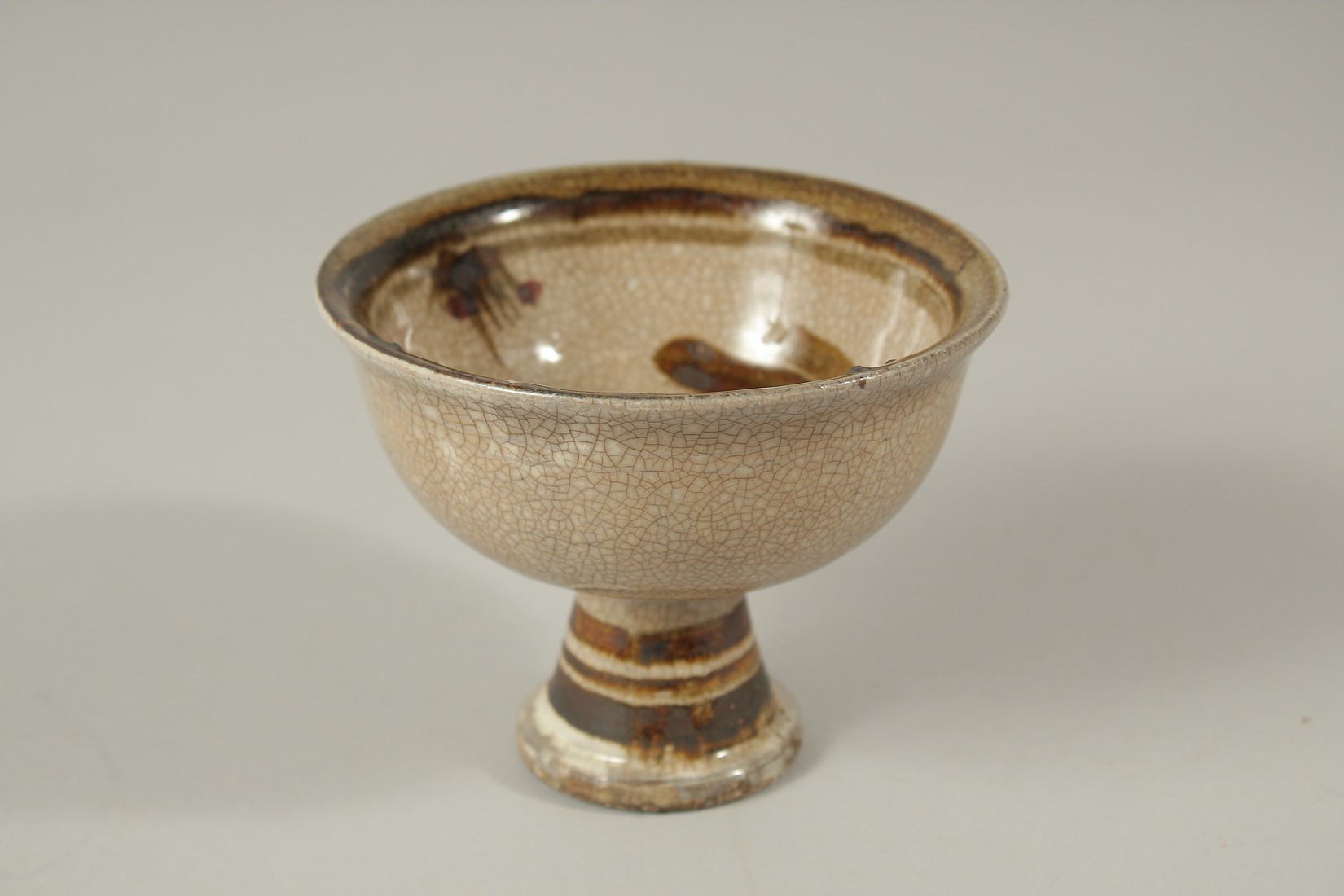 A CHINESE BROWN CRACKLE GLASS STEM CUP.