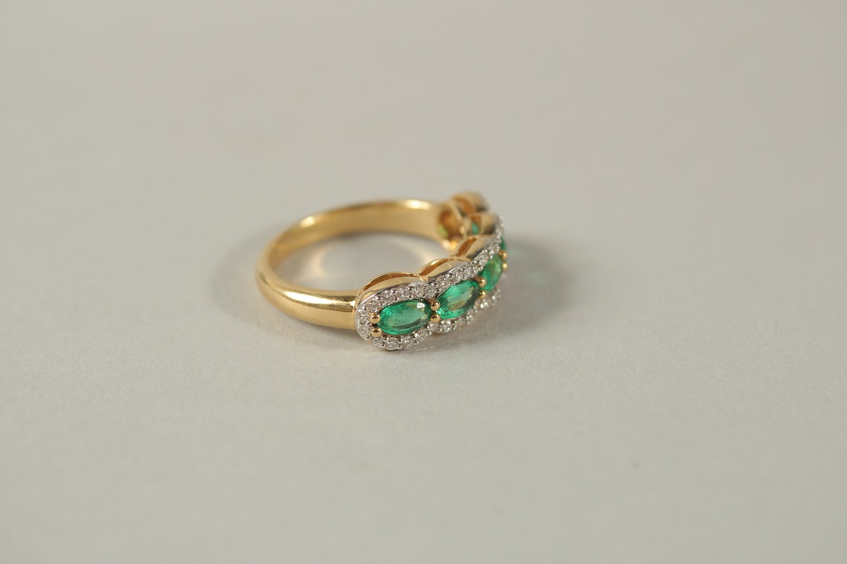 AN 18CT YELLOW GOLD FIVE STONE EMERALD AND DIAMOND HALF HOOP RING. - Image 3 of 7