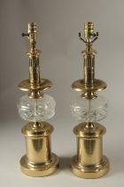A PAIR OF GILT METAL AND GLASS LAMPS. 54cms high.