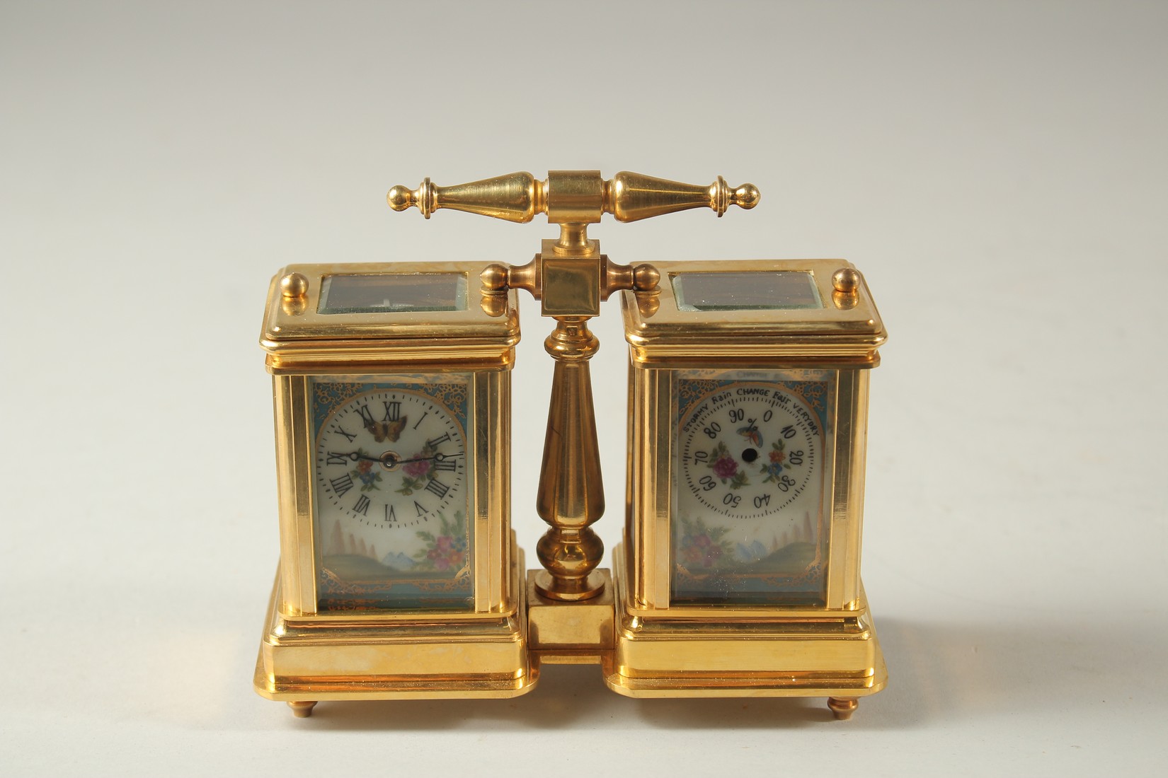 A SEVRES MODEL DOUBLE CARRIAGE CLOCK with porcelain panels and carrying handles. 10cms high.