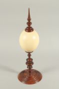 A GOOD OSTRICH EGG AND TURNED WOOD TABLE CENTREPIECE. 19ins high.