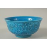 A CHINESE BLUE PORCELAIN BOWL with dragon in relief. Mark in blue. 15cms diameter.