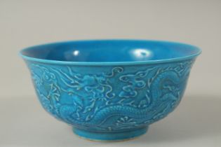 A CHINESE BLUE PORCELAIN BOWL with dragon in relief. Mark in blue. 15cms diameter.
