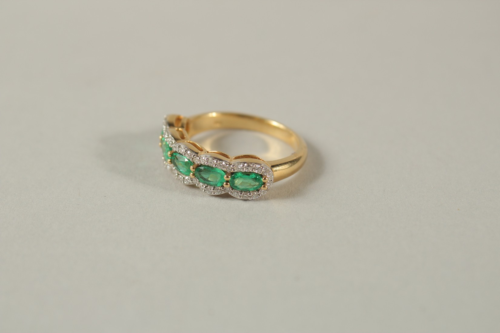 AN 18CT YELLOW GOLD FIVE STONE EMERALD AND DIAMOND HALF HOOP RING. - Image 2 of 7