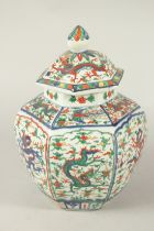 A CHINESE HEXAGONAL WUCAI GINGER JAR AND COVER, printed with panels of dragons. 30cms high.