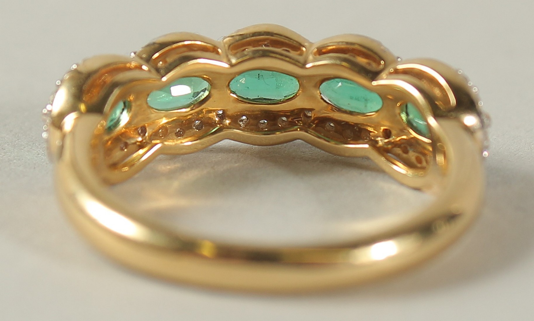 AN 18CT YELLOW GOLD FIVE STONE EMERALD AND DIAMOND HALF HOOP RING. - Image 7 of 7