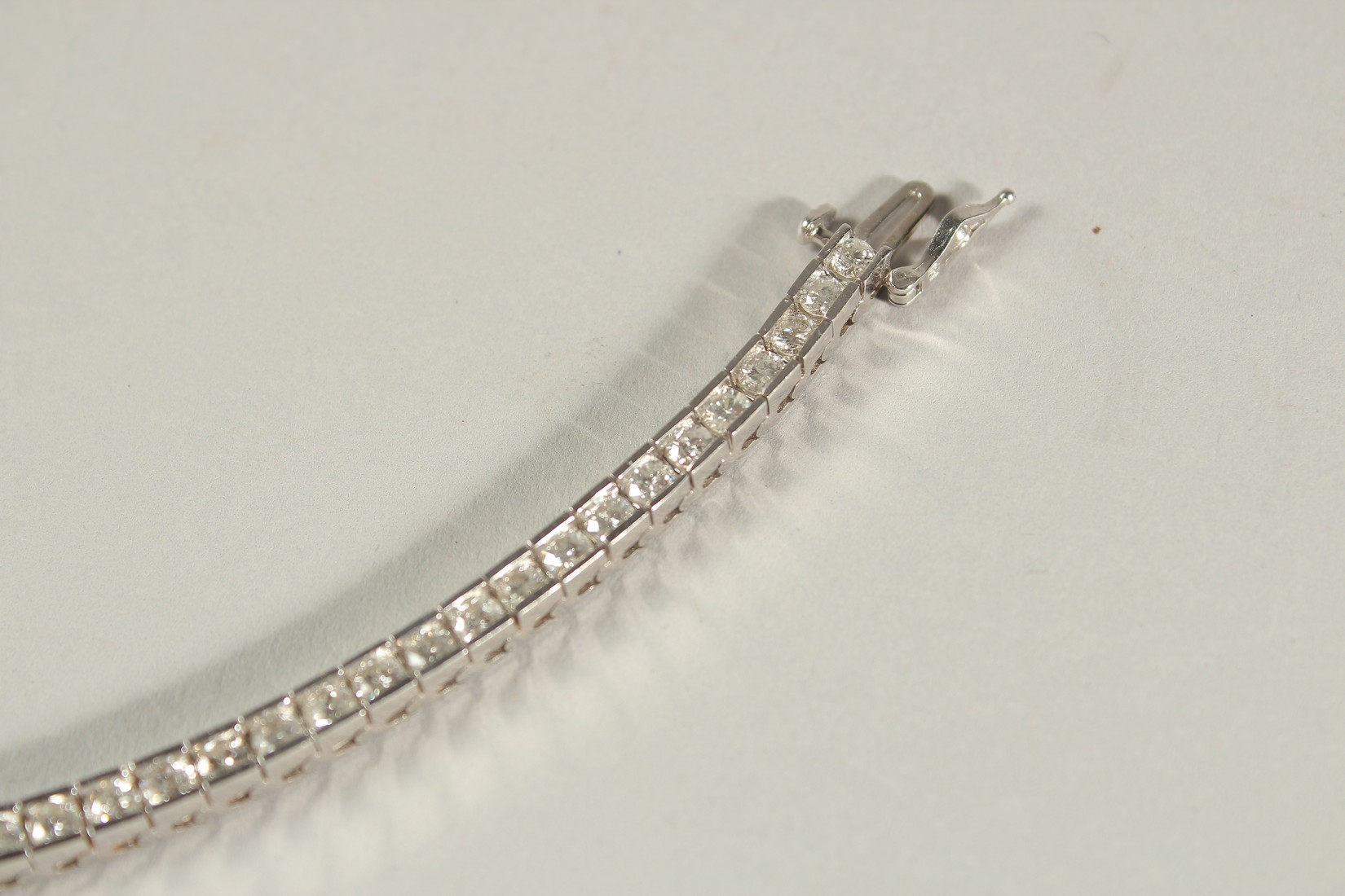 A 14CT WHITE GOLD SEMI-RUBOVER SET RBC DIAMOND LINE BRACELET, with an open blox clasp and safety - Image 2 of 8