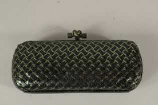 A BOTTEGA VENETA, ITALY, CLUTCH BAG, black cross hatch decoration, with dust cover. 24cms long.