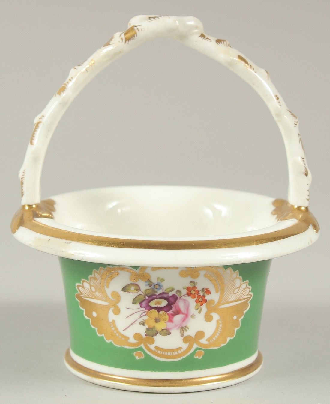 A GOOD SMALL ROCKINGHAM CIRCULAR BASKET and handle, green ground and painted with flowers.