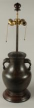 A CHINESE BRONZE TWIN HANDLE VASE CONVERTED TO A LAMP, mounted to a hardwood base, 70cm high