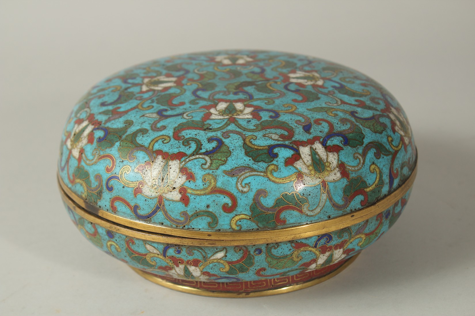 A 19TH CENTURY CHINESE BLUE GROUND CLOISONNE CIRCULAR LIDDED BOX, with floral motif decoration, 20.