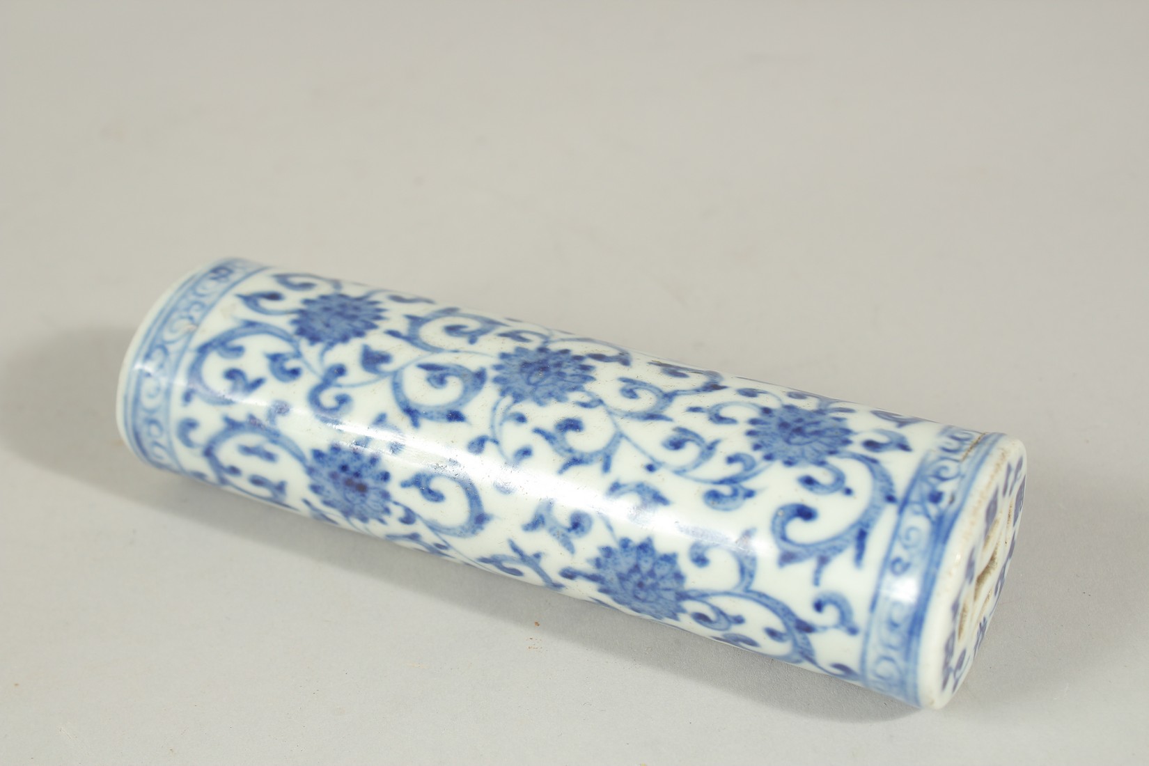 A 19TH CENTURY CHINESE BLUE AND WHITE PORCELAIN WRIST REST, with lotus and vine decoration and