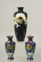 A CHINESE BLACK GROUND CLOISONNE VASE, 24cm high, together with a smaller pair of vases, (3).