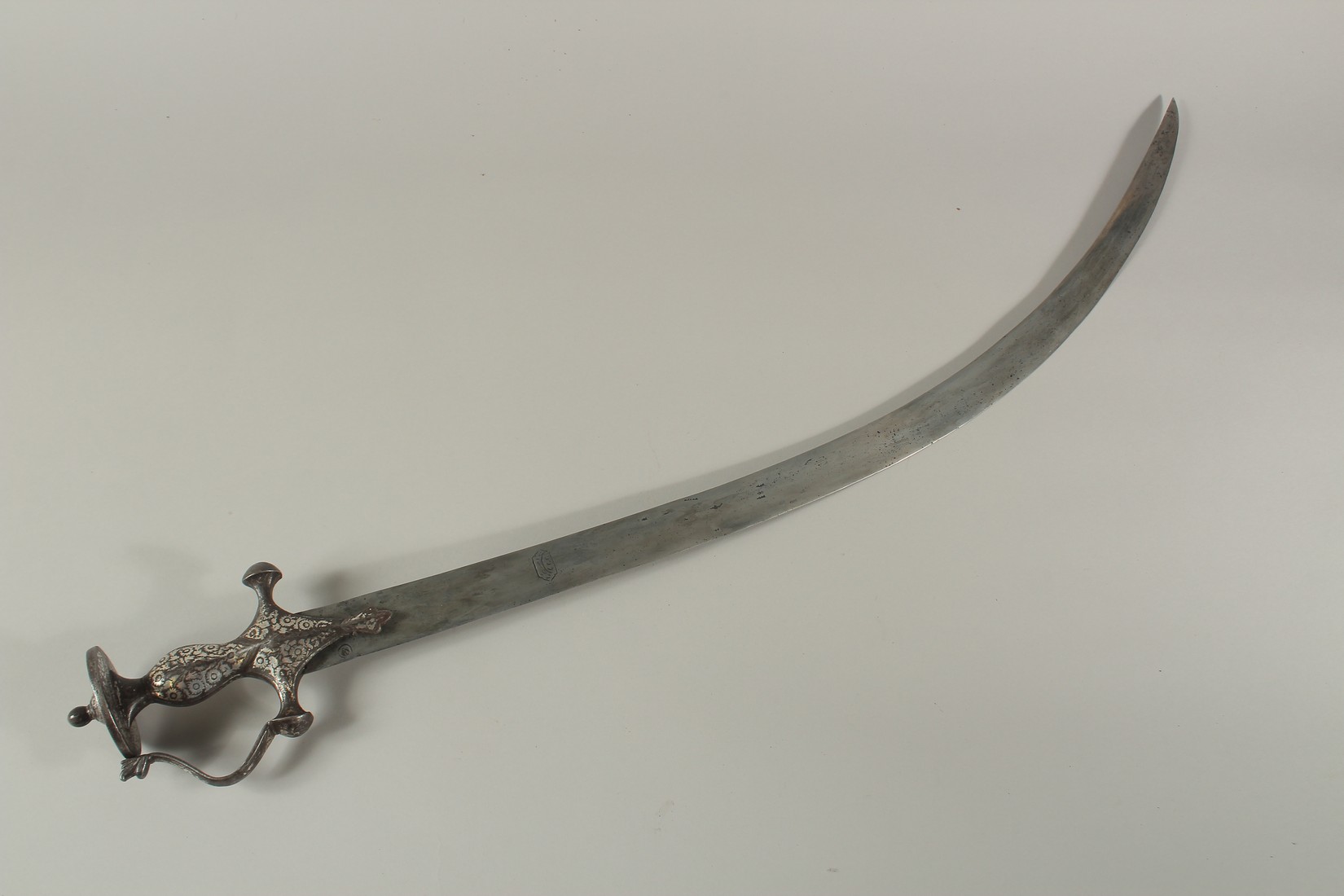 AN 18TH CENTURY MUGHAL INDIAN TULWAR SWORD, with silver inlaid hilt and signed blade.