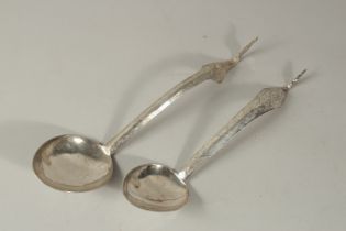A NEAR PAIR OF LARGE SILVER SPOONS WITH EMBOSSED BUDDHA TO HANDLES, 32cm long and 28cm long, (2).