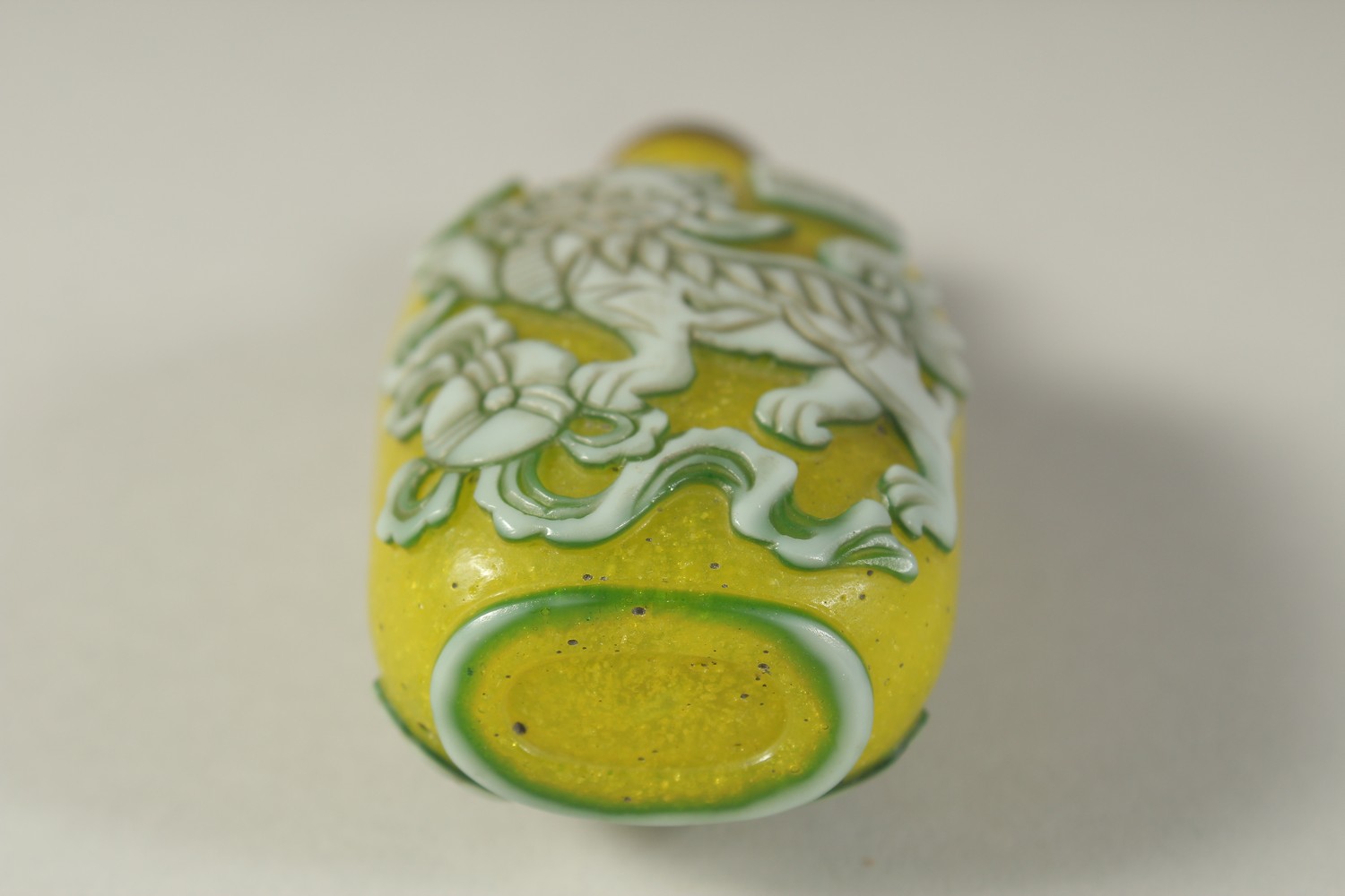 A CHINESE RELIEF-DECORATED FOO DOG SNUFF BOTTLE AND STOPPER / SPOON, 8cm high. - Image 4 of 4