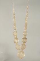 AN ISLAMIC CARVED ROCK CRYSTAL BEADED NECKLACE, beads of various sizes, largest bead 4cm.