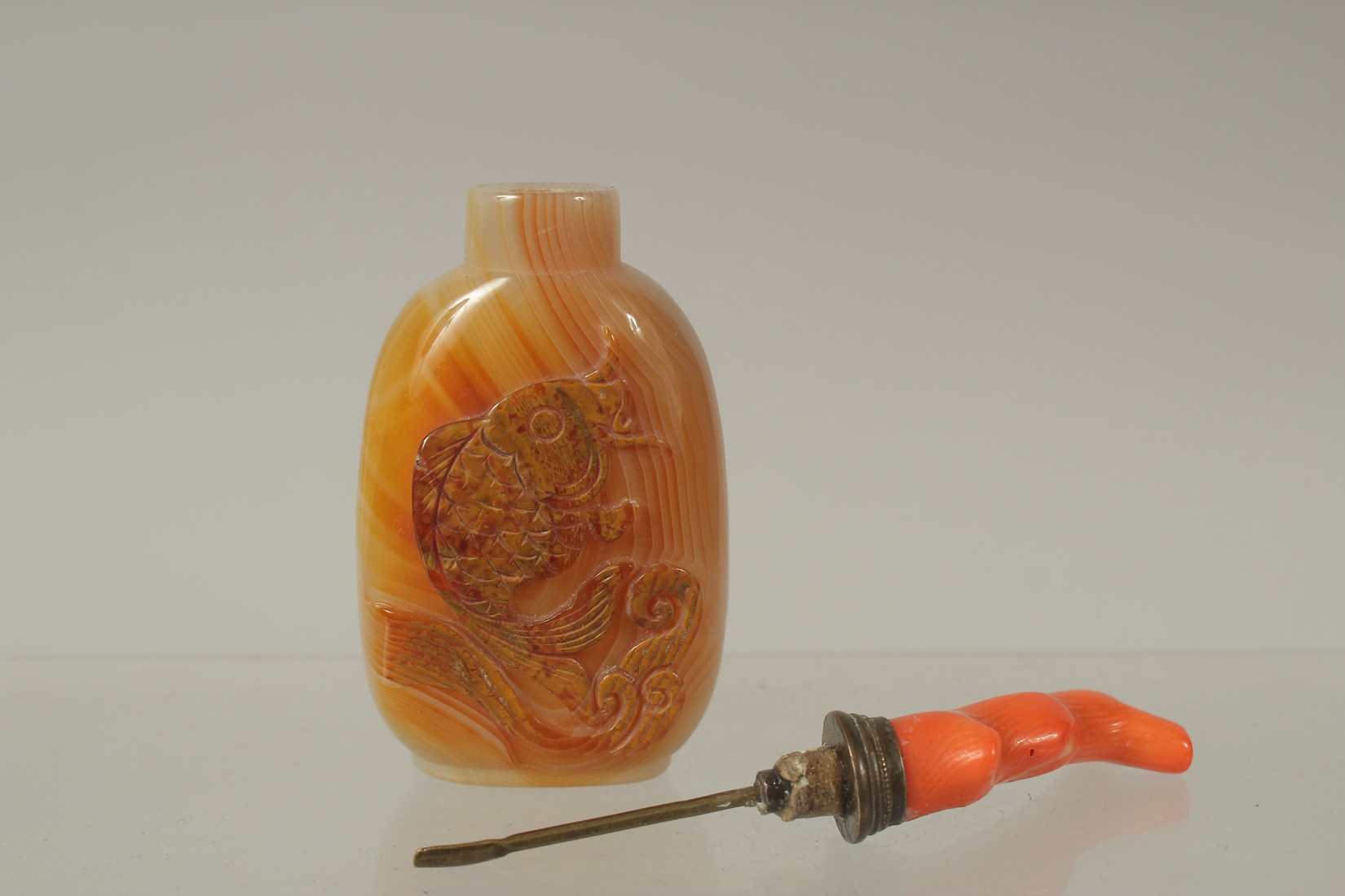 A CHINESE AGATE SNUFF BOTTLE WITH CORAL STOPPER, the bottle carved with carp, 11.5cm high overall. - Image 4 of 4