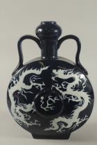 A CHINESE TWIN HANDLE SACRIFICIAL BLUE PORCELAIN MOON FLASK, with incised white dragons, 38cm high.