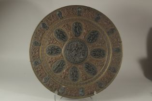 A LARGE INDIAN MIXED METAL BRASS CHARGER, with oval panels of deities, 52cm diameter.