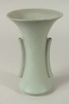 A CHINESE CELADON GLAZED PORCELAIN TRUMPET-FORM VASE, with twin handles, the with incised