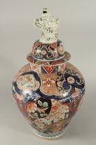 A FINE AND LARGE JAPANESE IMARI PORCELAIN JAR AND COVER, painted with large panels of flora and