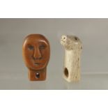 TWO ANTIQUE CARVED INUIT JEWELLERY PIECES, one of a carved bone animal, the other carved as a