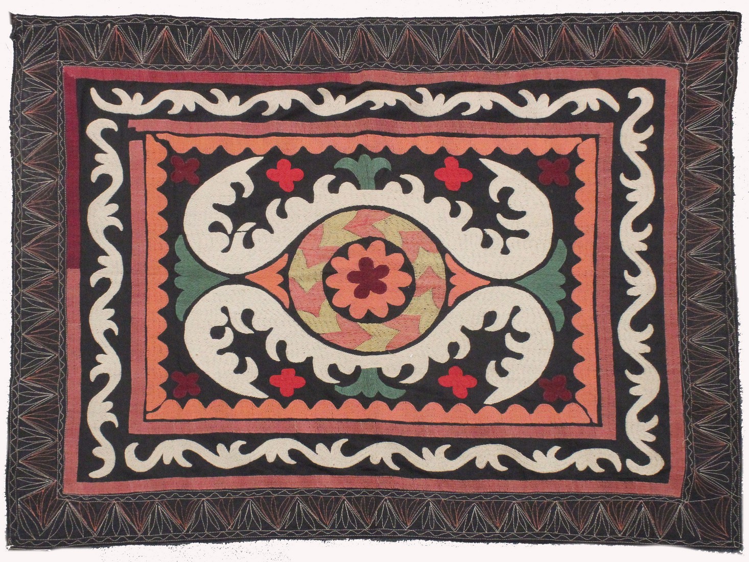 AN UZBEK SUZANI EMBROIDERED TEXTILE, with central foliate motif in orange, green, maroon, red, and