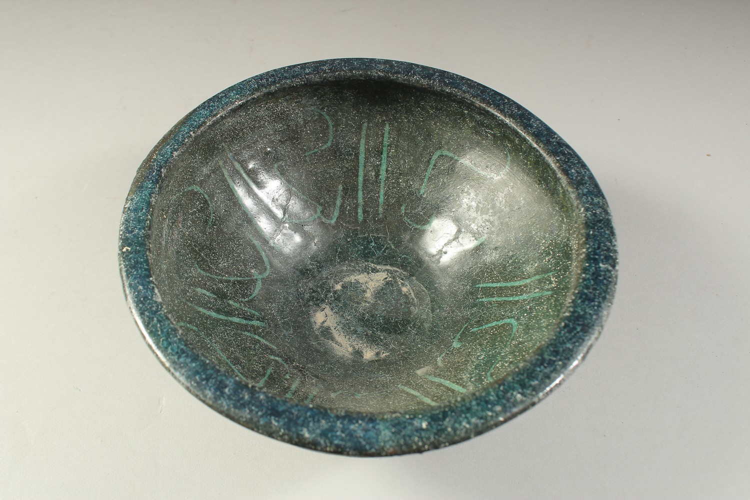 A 12TH CENTURY NISHAPUR GLAZED POTTERY BOWL, the interior with calligraphy, 19cm diameter. - Image 2 of 3