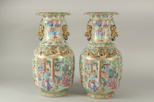 A FINE PAIR OF CHINESE CANTON FAMILLE ROSE PORCELAIN VASES, painted with panels of various figures