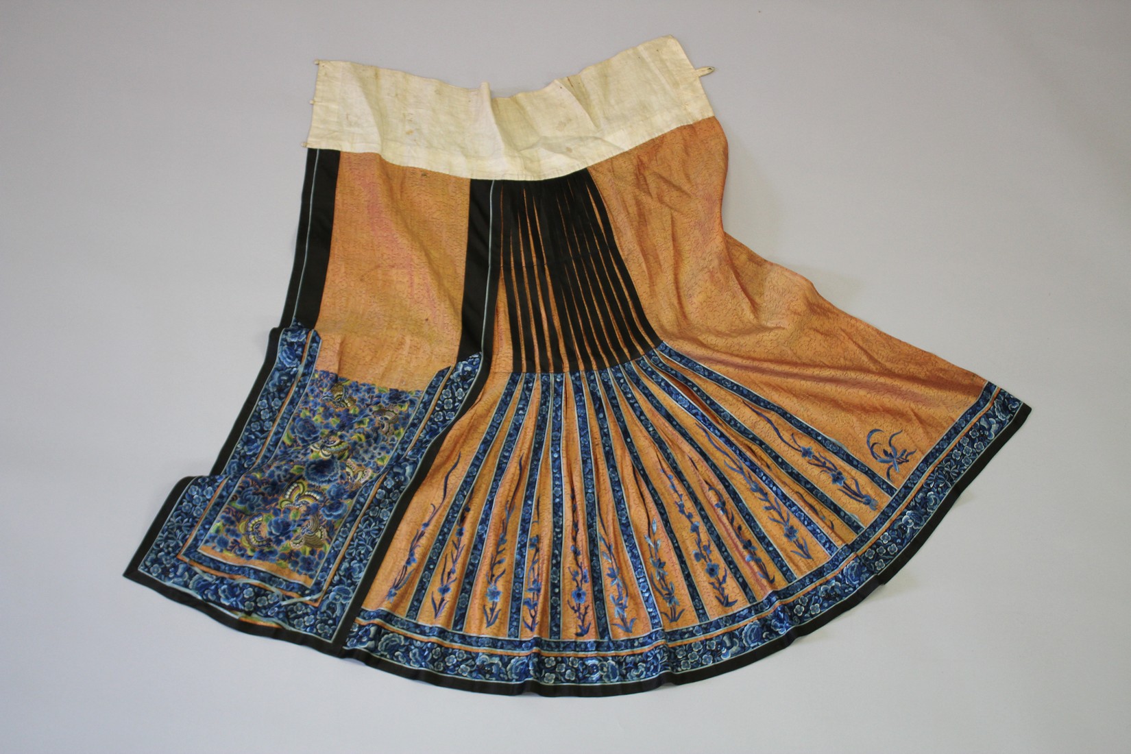 A CHINESE FINELY EMBROIDERED SILK SKIRT, with butterflies and flowers in blue thread.