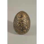 A RARE SOUTH EAST ASIAN POSSIBLY INDONESIAN TALISMANIC BRASS EGG, 6cm.